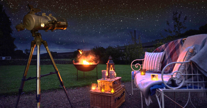 View of an open fire, chair and telescope in the garden at Lord Crewe Arms hotel.